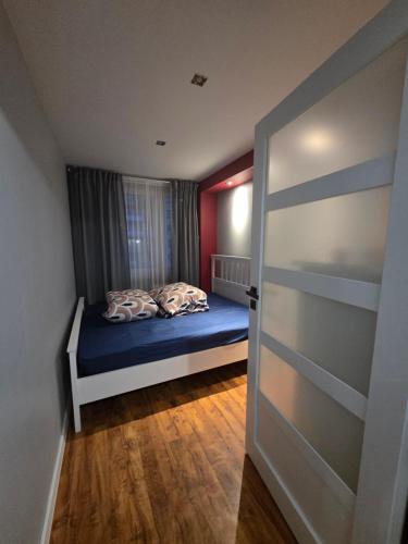 ザビエルチェにあるApartament KAROの小さなベッドルーム(ベッド1台、ドア付)
