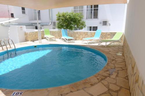 a swimming pool in the middle of a building with chairs at Hotel Vibra Lei Ibiza - Adults only in Ibiza Town