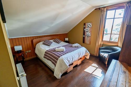 a bedroom with a bed and a chair at Hotel San Giorgio in Capitán Pastene