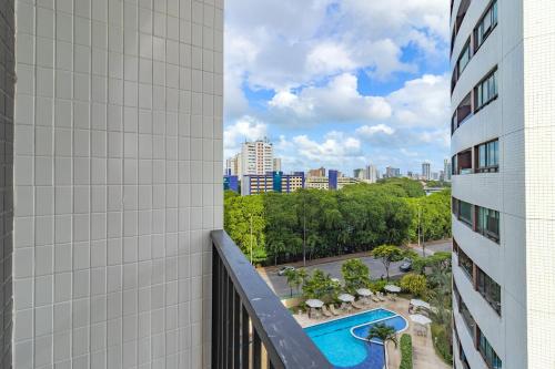 a view from the balcony of a building with a swimming pool at Tolive Riverside HOUSI by Carpediem in Recife
