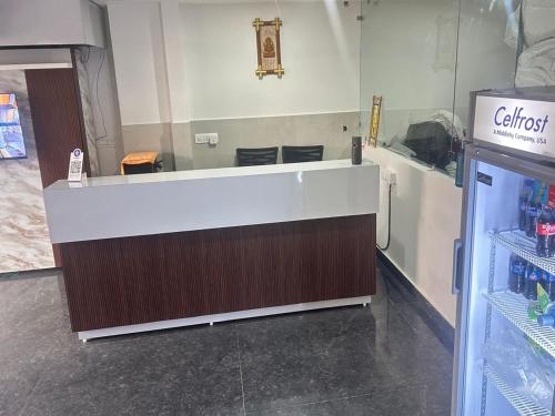 a cashier counter in a store with a refrigerator at Akshay premium suites1 BHK Serviced Apartments Near Artemis Hospital Sector 52 in Gurgaon