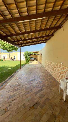 a patio with white chairs and a wooden ceiling at VIP eventos in Juazeiro do Norte