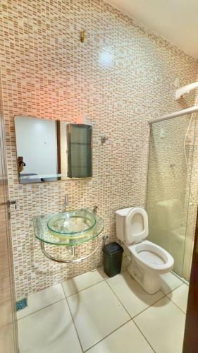 a bathroom with a glass sink and a toilet at VIP eventos in Juazeiro do Norte