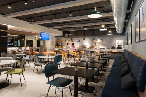 a restaurant with tables and chairs and a bar at voco Bilbao - City by IHG in Bilbao