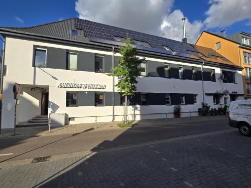 a white building on the side of a street at Top-Floor Hideaway for Two in Karlsruhe-Mühlburg - APOLONIAliving - Apt3 in Karlsruhe