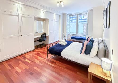 a bedroom with a bed and a desk in it at Modern 3-Bedroom Baker Street flat near Mayfair, Oxford Street & West End in London
