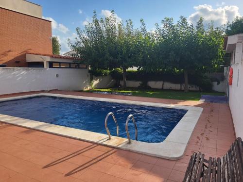 a swimming pool with two metal handles in a yard at Adosado cerca de la playa, relax in Benicàssim