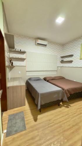 a bedroom with two beds and a rug at VIP eventos in Juazeiro do Norte