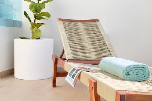a wooden rocking chair with a blue towel on it at Silvic Aguaviva in Cotillo