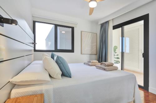 a bedroom with a white bed with blue pillows at Silvic Aguaviva in Cotillo