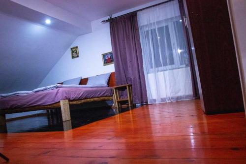 a bedroom with a bed with purple sheets and a window at Casa Adriana in Ileni