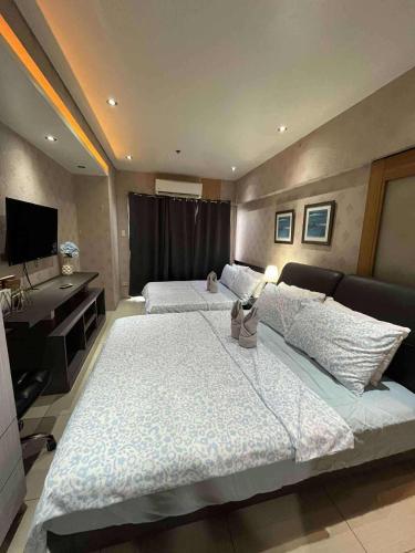 Giường trong phòng chung tại Staycation Near Mall of Asia