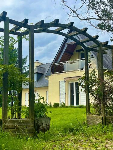 a wooden pergola in front of a house at Foxgloves in La Motte