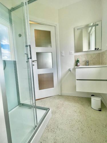 a bathroom with a glass shower and a sink at Foxgloves in La Motte