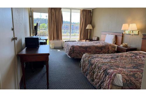 a hotel room with two beds and a desk at Hotel O Star Motel Hattiesburg HWY 49 in Hattiesburg