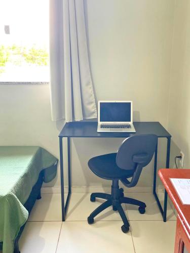 a desk with a laptop and a chair in a room at Casa em Condomínio, Jardim, Home Office in Castanhal
