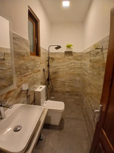 a bathroom with a toilet and a sink at Ella Holly House in Ella