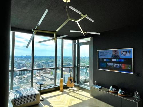 a living room with a ceiling fan and a large window at Luxe Lakeview, steps to CN tower & Rogers centre in Mississauga