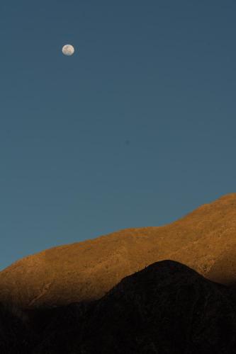 a moon over a hill with a blue sky at Casa los Molles Hostel in Maimará