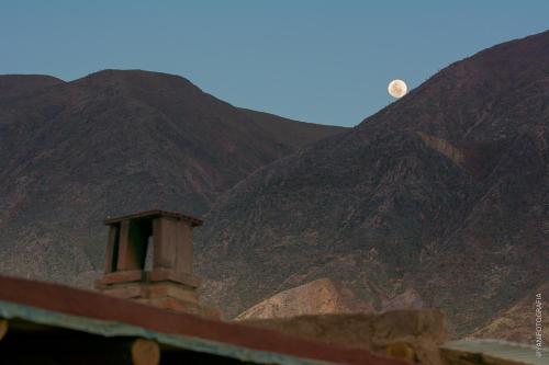 a view of a mountain with a moon in the sky at Casa los Molles Hostel in Maimará