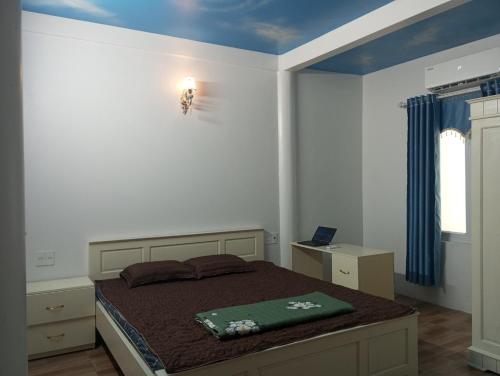 a bedroom with a bed with a green blanket on it at Trần Sơn Homestay in Tuyên Quang