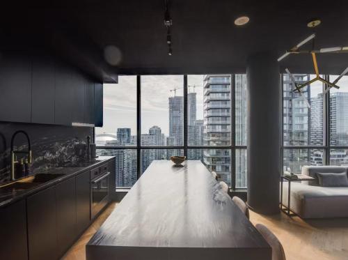 a kitchen with a large table in front of a large window at Luxe Lakeview, steps to CN tower & Rogers centre in Mississauga