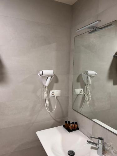 a bathroom with a white sink and a mirror at Hotel Boa Vista in Viveiro