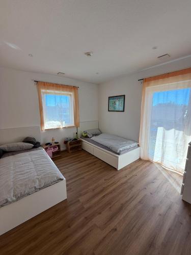 una camera da letto con due letti e due finestre di Samtenssonne a Samtens