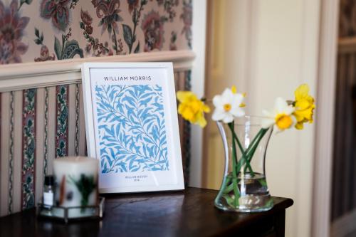 a table with a card and flowers in a vase at Charming 18th Century property in Topcliffe Station