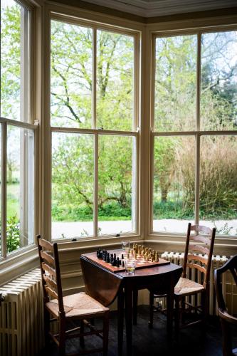 a room with a chess board on a table in front of windows at Charming 18th Century property in Topcliffe Station