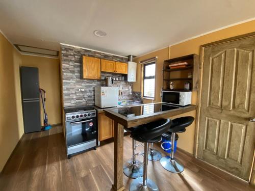 a kitchen with a counter and a stove top oven at Apartamentos Natales May 21 in Puerto Natales