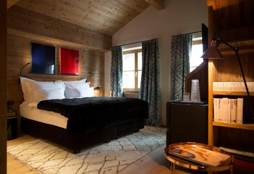 a bedroom with a bed with a black comforter at House Hannes Schneider Stuben in Stuben am Arlberg