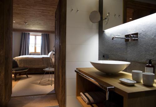 a bathroom with a sink and a room with a bed at House Hannes Schneider Stuben in Stuben am Arlberg