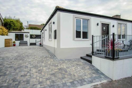 a white house with a brick driveway at Wiston Street - 2 Bedroom Holiday Home - Pembroke in Pembroke