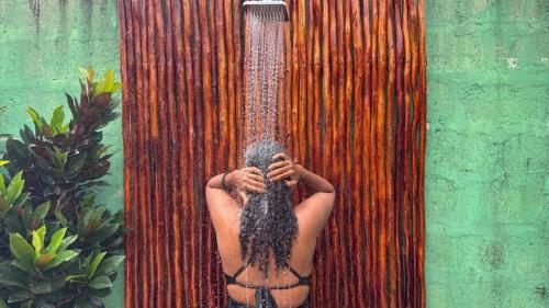 a man with long hair is in a shower at Outdoor Cinema Group Friendly Retreat in Pingwe