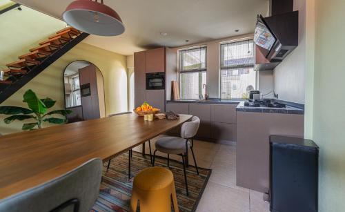 a kitchen with a long wooden table and chairs at Hanzestekje Harderwijk in Harderwijk