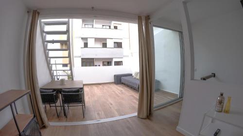 Una habitación con una mesa y sillas y una ventana grande. en Sita Urban Home, en Las Palmas de Gran Canaria