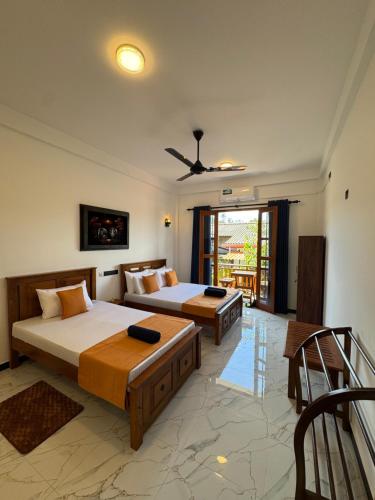 a bedroom with two beds and a balcony at Beach heaven villa in Matara