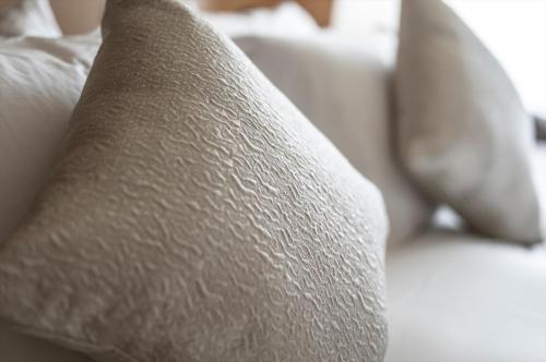 a close up of a white couch with pillows at Villa Sanjomuromachi KYOTO in Kyoto