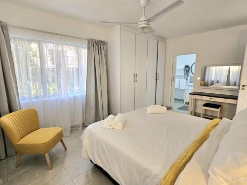 une chambre avec un lit, une chaise et une télévision dans l'établissement ONE on Michelle, à Ballito