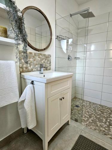 a white bathroom with a sink and a shower at ONE on Michelle in Ballito