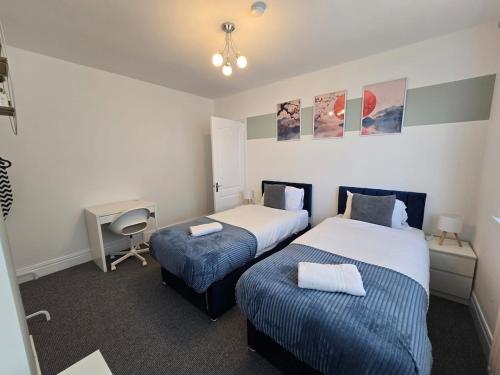Una habitación de hotel con dos camas y un escritorio. en Spacious 3BR Sleeps 6 Ideal for All Stays, en Dunston
