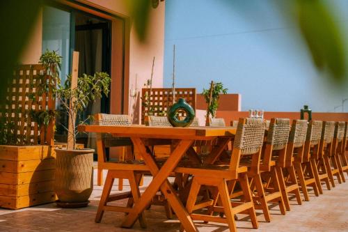 a wooden table with a row of chairs around it at Flooka Surf & Yoga in Imsouane
