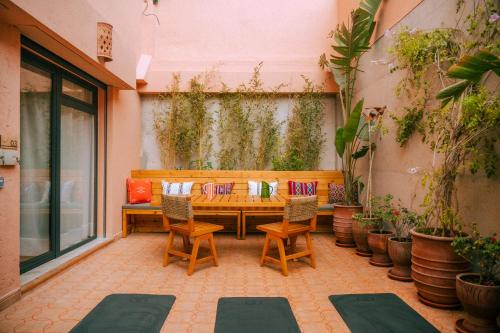 a patio with a bench and chairs and plants at Flooka Surf & Yoga in Imsouane