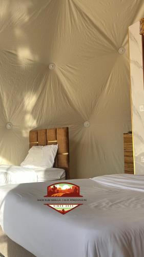 two beds in a room with a tent at Wadi Rum Nebula, Calm Atmosphere in Wadi Rum