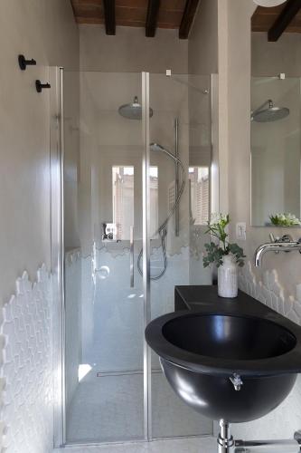un bagno con lavandino nero e doccia di Palazzo Gramsci a Tatti