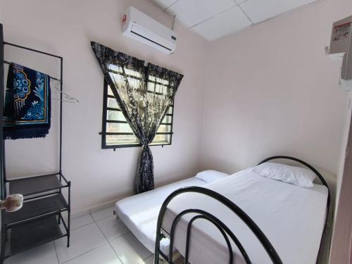 a bedroom with a bed and a window at Nariz Homestay Kuala Ketil in Kuala Ketil