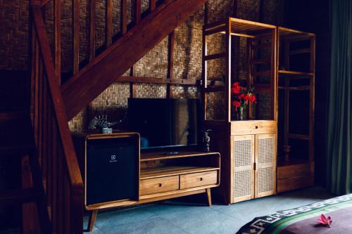 a entertainment center with a television in a room at Corabelle Gili Air in Gili Air