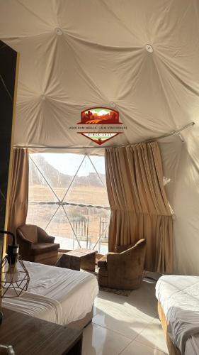a room with two beds and a tent at Wadi Rum Nebula, Calm Atmosphere in Wadi Rum