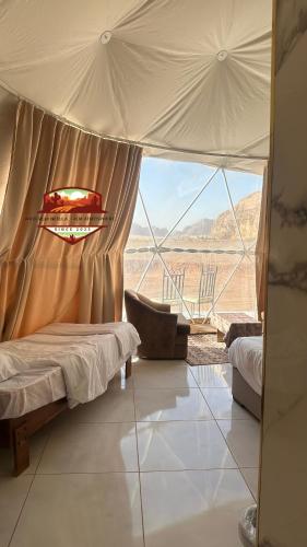 a bedroom with a bed and a large window at Wadi Rum Nebula, Calm Atmosphere in Wadi Rum